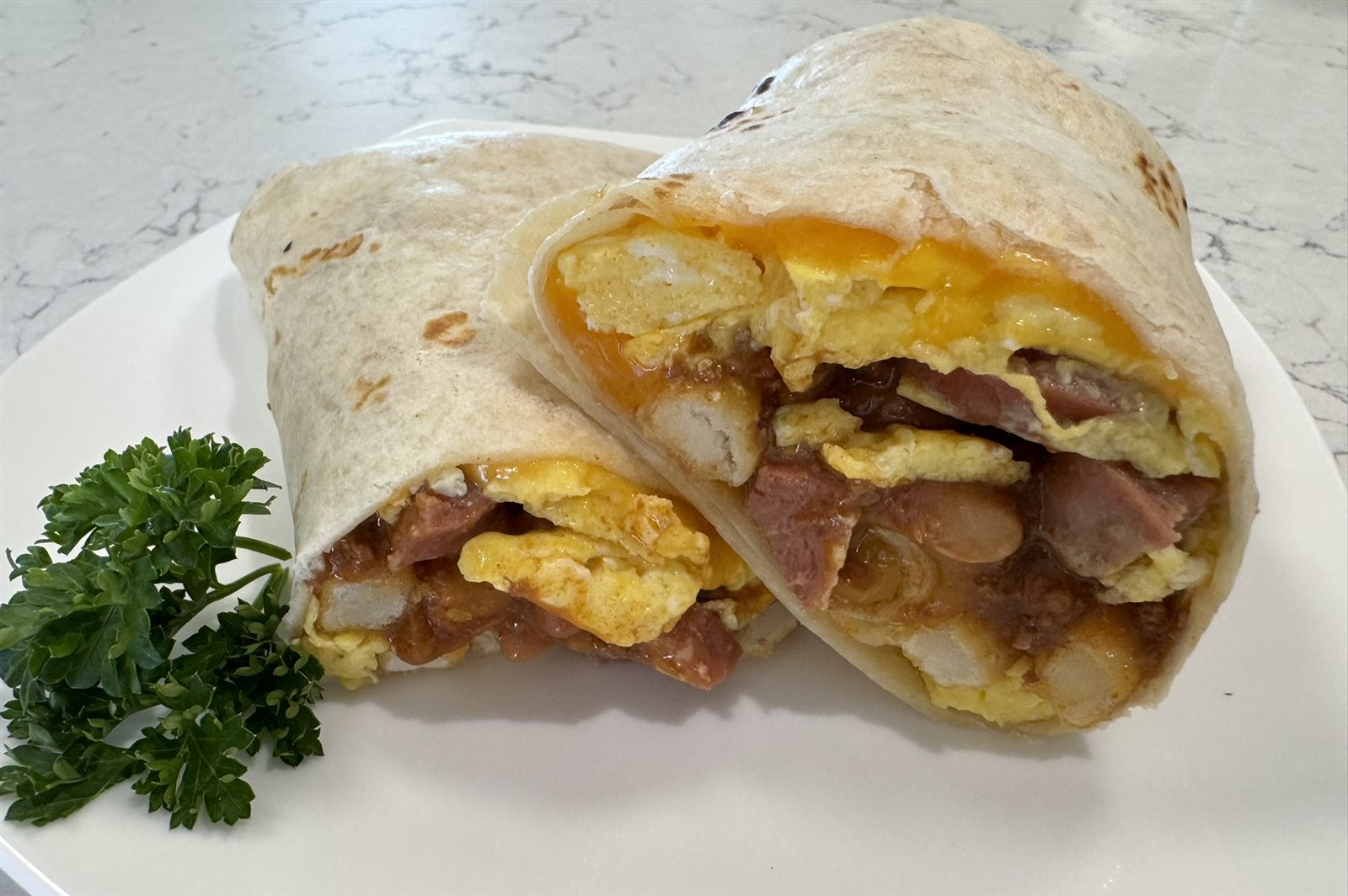 Breakfast burrito cut open to show eggs, potato, and chili