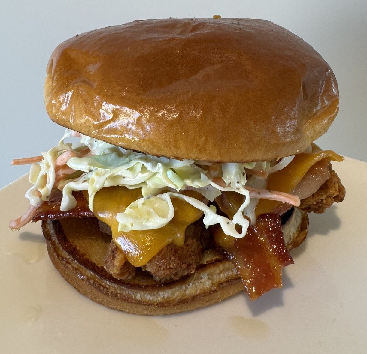 Crispy chicken sandwich with bacon, cheese, and slaw