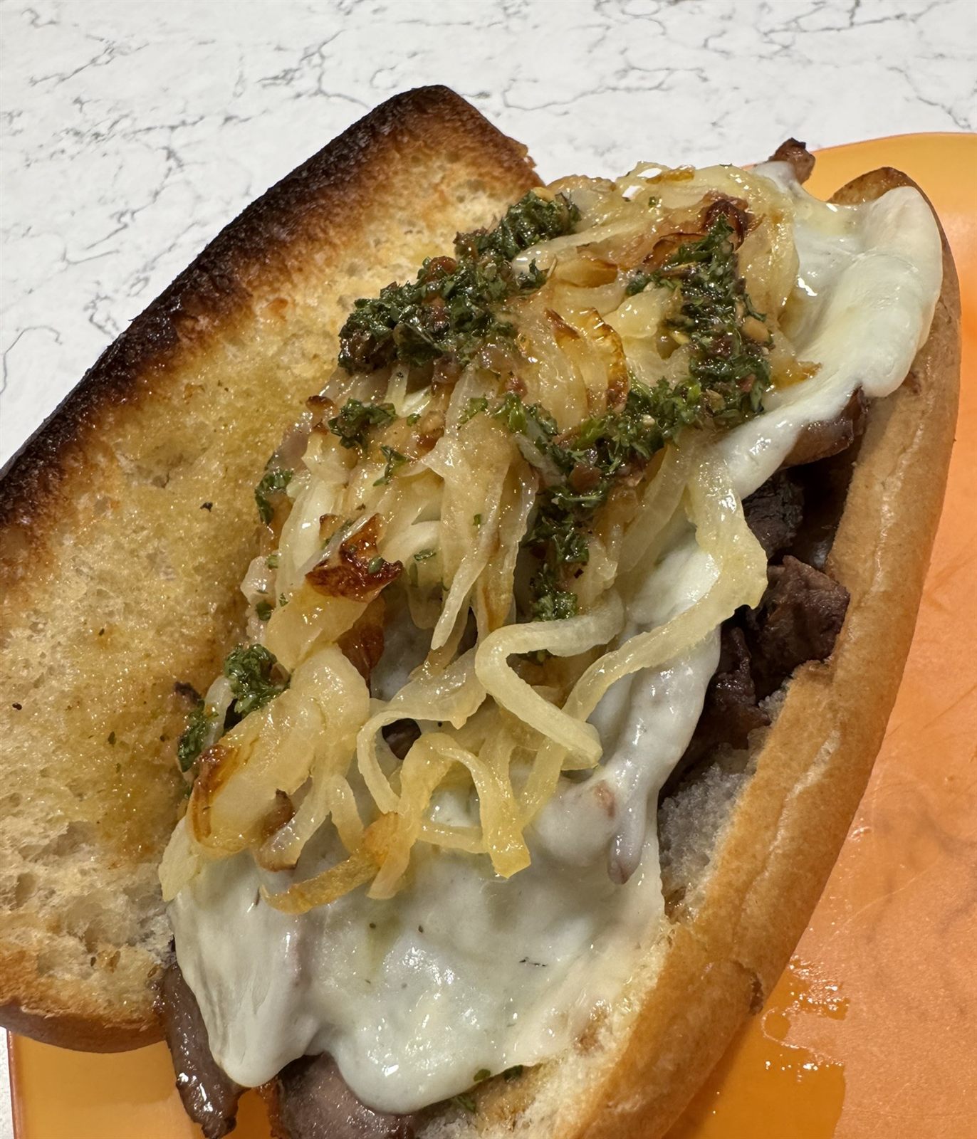 Steak sandwich with grilled onion and herbs